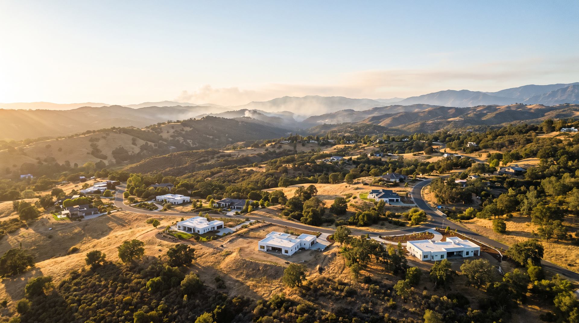 Hillside homes in wildfire country at golden hour.
